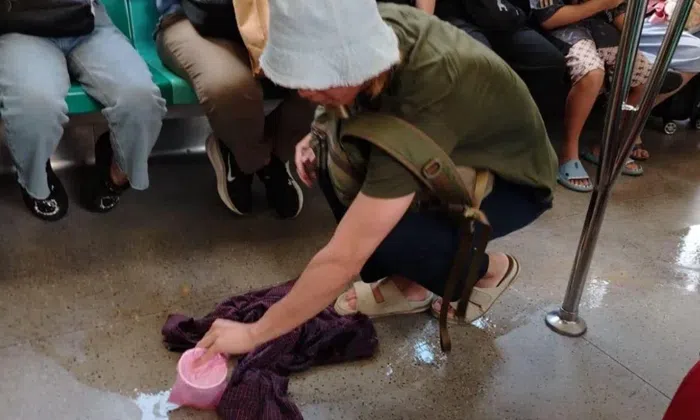 Young man praised for using own T-shirt to clean tea spill on MRT train Young man praised for using own T-shirt to clean tea spill on MRT train