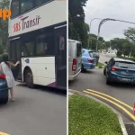 Double-decker bus narrowly misses woman who left car door open after stopping on busy road
