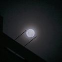 Wolf supermoon peers through cloudy night sky above Singapore