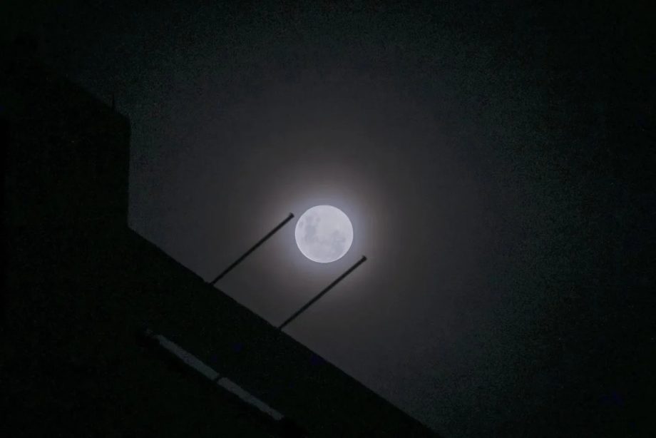 Wolf supermoon peers through cloudy night sky above Singapore