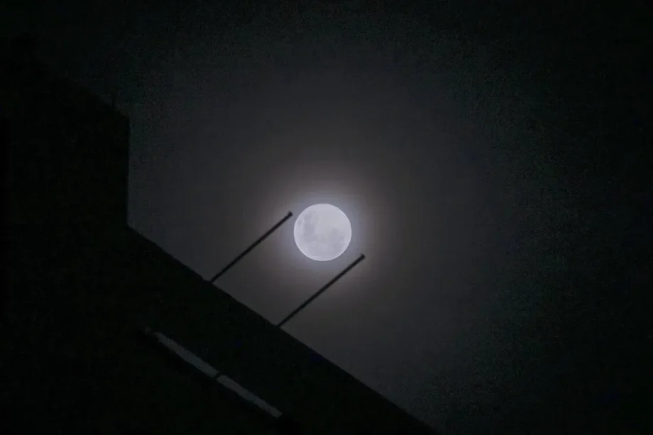 Wolf supermoon peers through cloudy night sky above Singapore