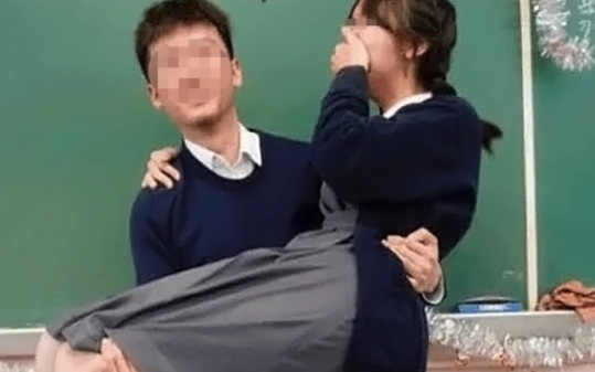 A photo of a male teacher hugging a girl in a classroom in Hong Kong has sparked controversy online…