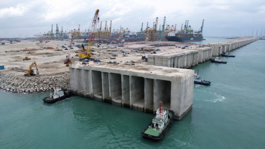 Singapore builds the largest megaport on the planet with 448 underwater concrete blocks weighing 15,000 tons, creates 681 hectares of land in the sea, and prepares an automated terminal capable of handling 65 million containers per year with AI and 450-meter mega ships. Singapore builds the largest megaport on the planet with 448 underwater concrete blocks weighing 15,000 tons, creates 681 hectares of land in the sea, and prepares an automated terminal capable of handling 65 million containers per year with AI and 450-meter mega ships.