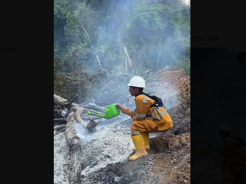 Indonesian fire fighter caught using small, watering can to put out the flames Indonesian fire fighter caught using small, watering can to put out the flames