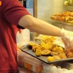 Ubi stall employee puts yong tau foo ingredients on tray